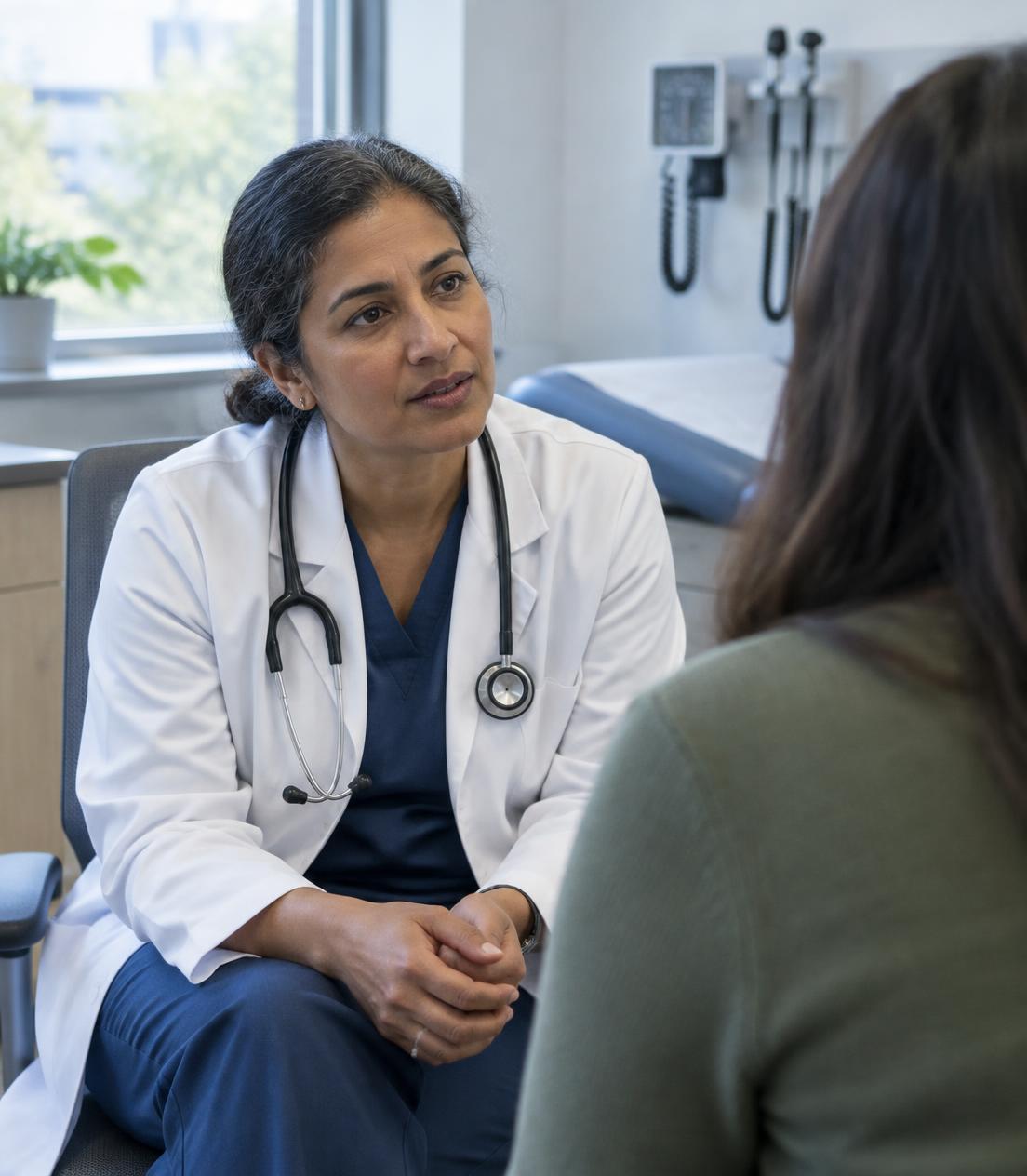 Physician speaking with a patient in an exam room